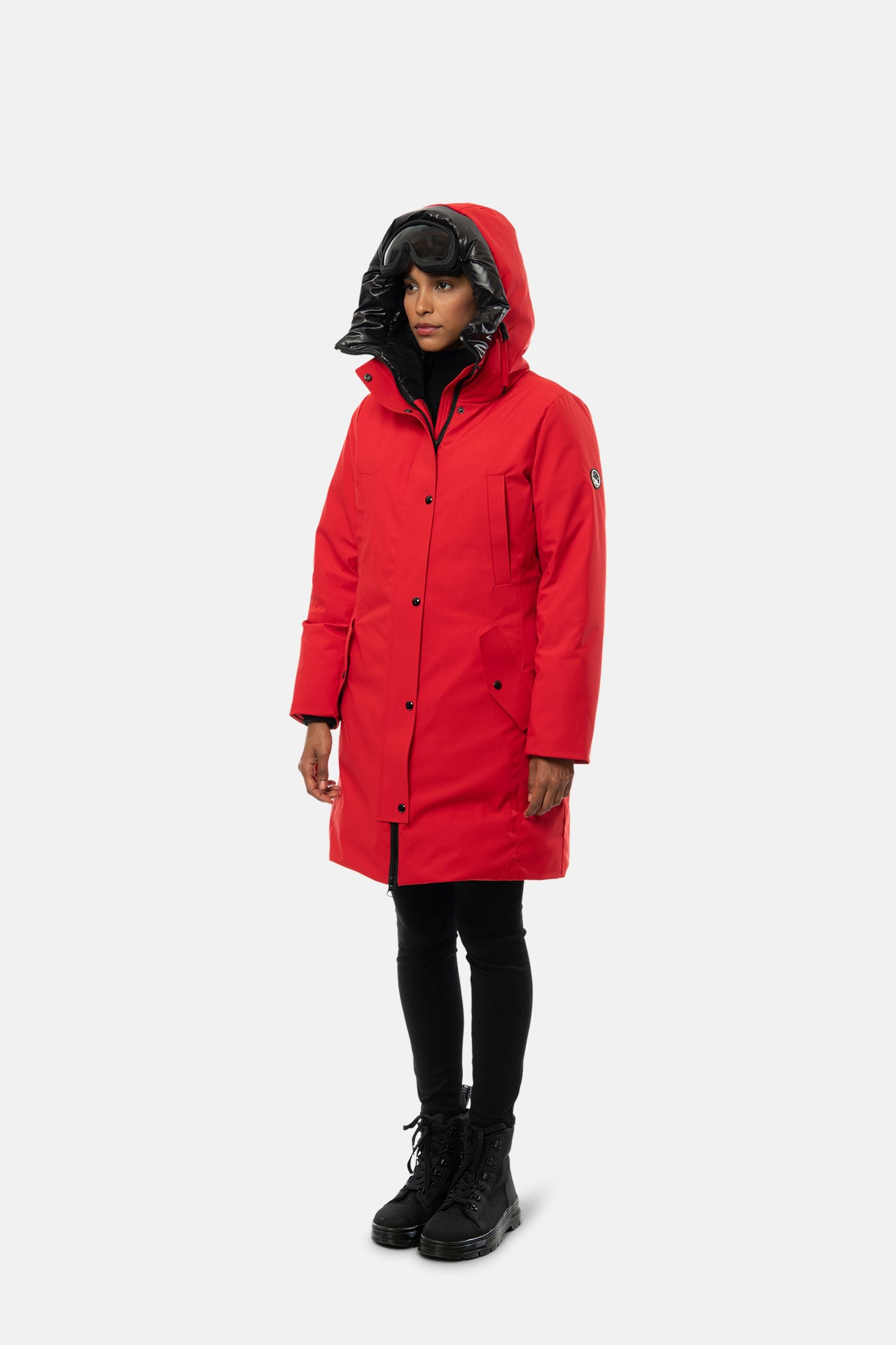 Woman wearing bright red hooded parka with ski goggles